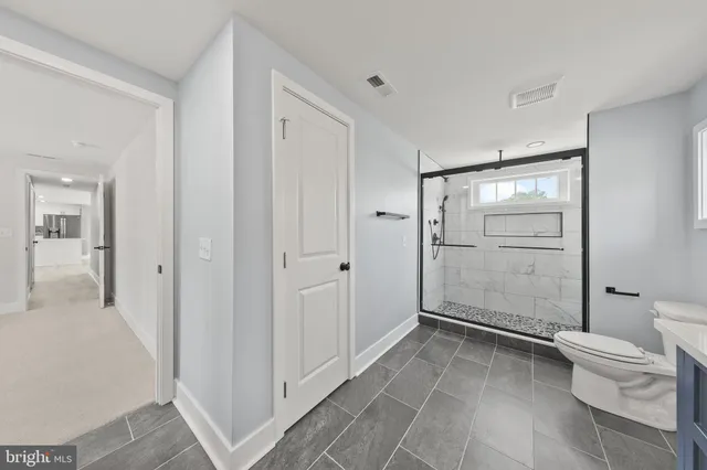 a bathroom with a double vanity sink mirror and toilet