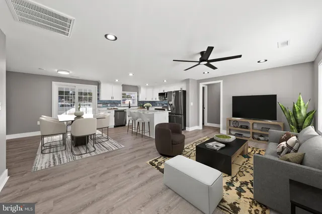 a living room with furniture kitchen view and a potted plant