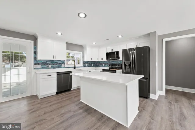 a kitchen with stainless steel appliances a refrigerator sink and cabinets