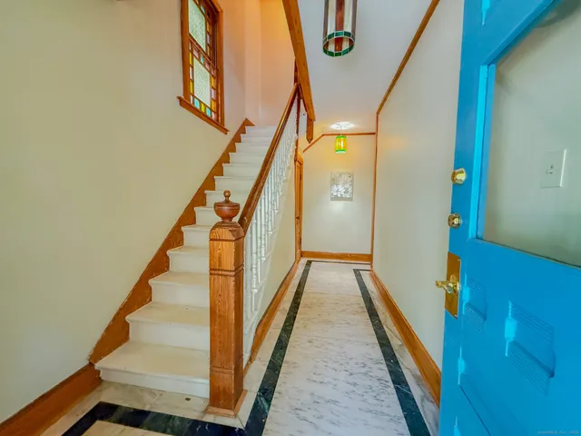 a view of staircase with lots of frames on wall and wooden floor