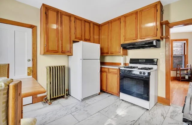 a kitchen with a refrigerator and a stove top oven