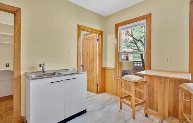 a view of a kitchen with a table and chairs in it