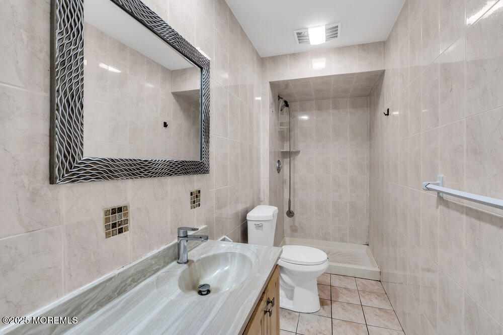 52 16th Street Toms River, NJ 08753 - Photo 19 of 44 a bathroom with a granite countertop sink toilet a shower and a mirror