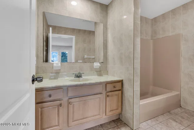 a bathroom with a tub sink and mirror