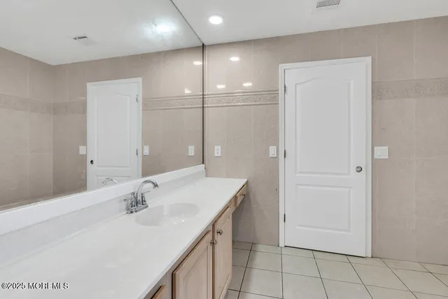 a bathroom with a sink vanity and a mirror