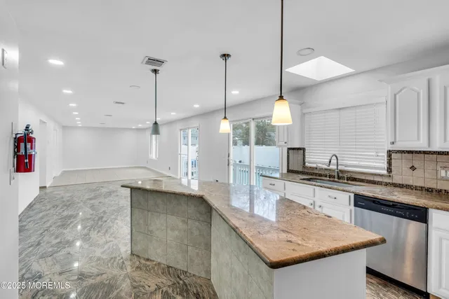 a large kitchen with kitchen island a sink stove and wooden floor