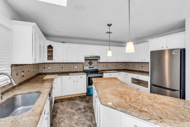 a kitchen with stainless steel appliances granite countertop a sink refrigerator and microwave