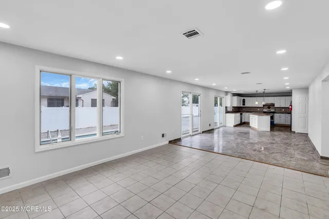an empty room with wooden floor and a large window