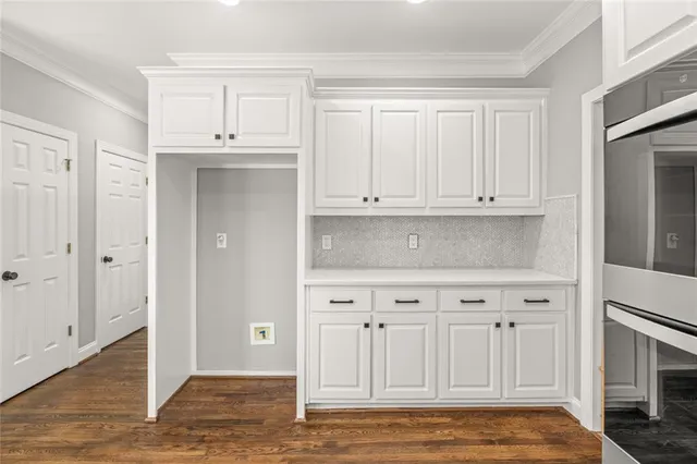 a view of white cabinets and wooden floor