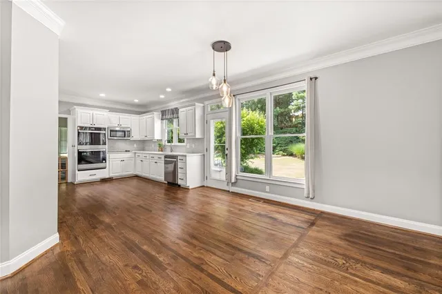 a view of a kitchen with furniture and wooden floor