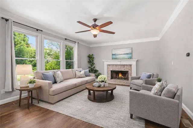 a living room with furniture a fireplace and a large window