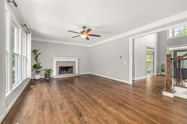 a view of empty room with wooden floor and fireplace