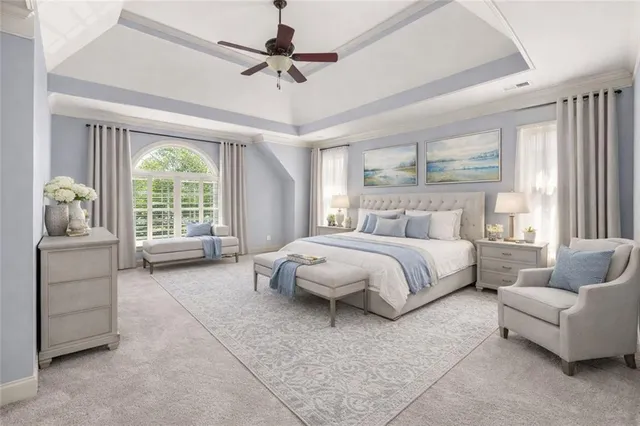 a spacious bedroom with a bed a couch and large window