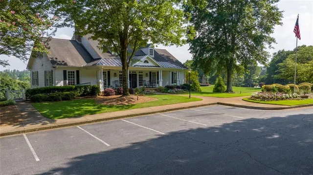 a front view of a house with a yard and green space