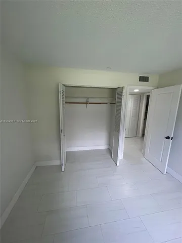 an empty room with a fireplace and cabinet