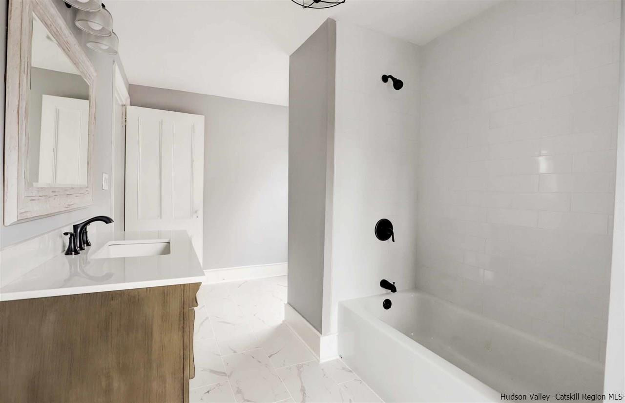 53 Spring Street Kingston, NY 12401 - Photo 17 of 26 a bathroom with a tub a sink and mirror