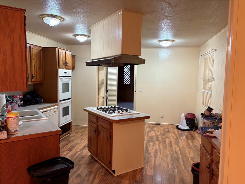 514 Fish Haven Road Graford, TX 76449 - Photo 6 of 21 a kitchen with stainless steel appliances granite countertop a stove and a wooden floors