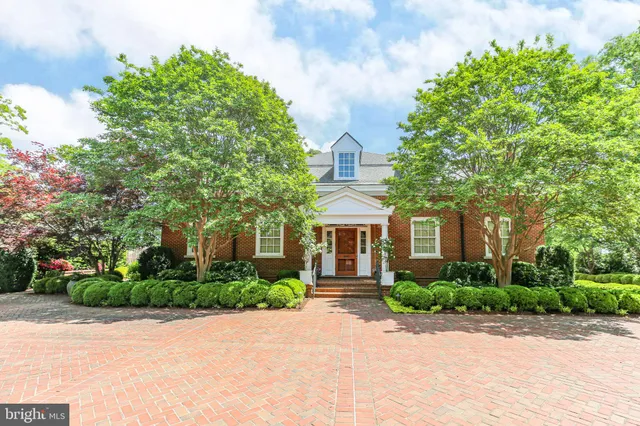 an aerial view of residential house with outdoor space and trees all around