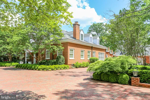 an aerial view of a house with garden space and trees all around