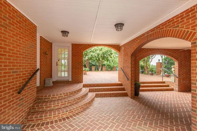a view of empty room with wooden floor and kitchen view