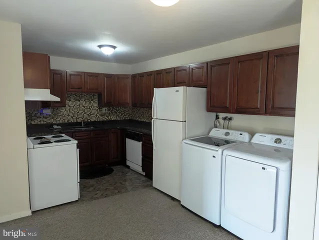 a kitchen with a white stove top oven and refrigerator