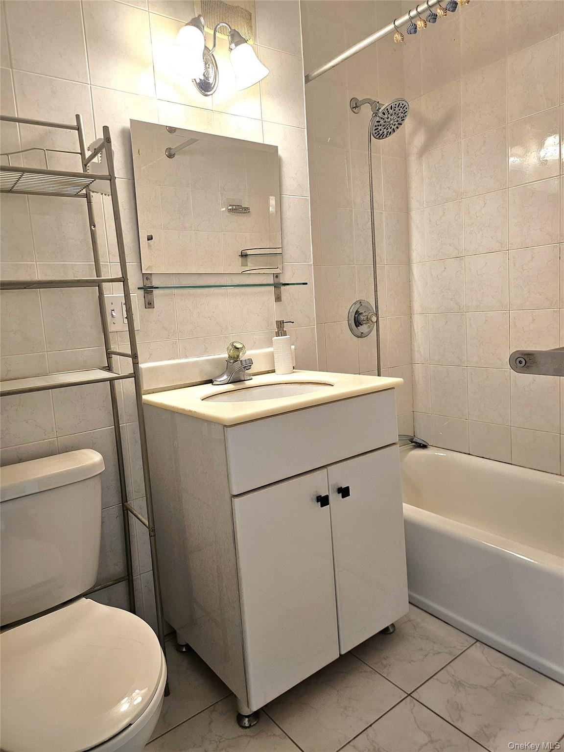 98-25 64th Road, Unit 8F Queens, NY 11374 - Photo 7 of 8 a bathroom with a sink a toilet and shower