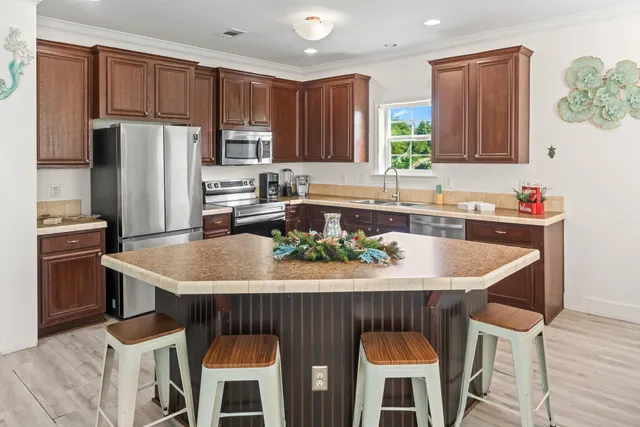 a kitchen with granite countertop a table chairs stove and refrigerator