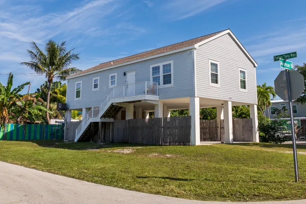 a kitchen with stainless steel appliances granite countertop a dining table chairs refrigerator and sink