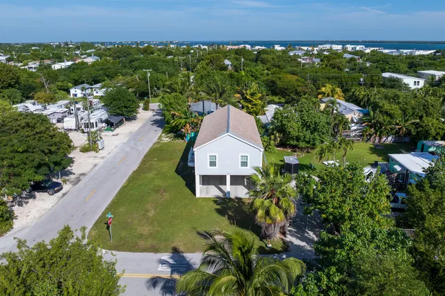 an aerial view of a house with a garden and lake view