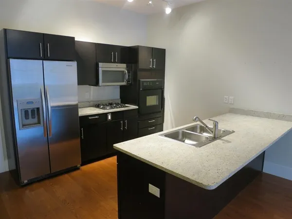 a kitchen with stainless steel appliances granite countertop a sink a refrigerator and a refrigerator