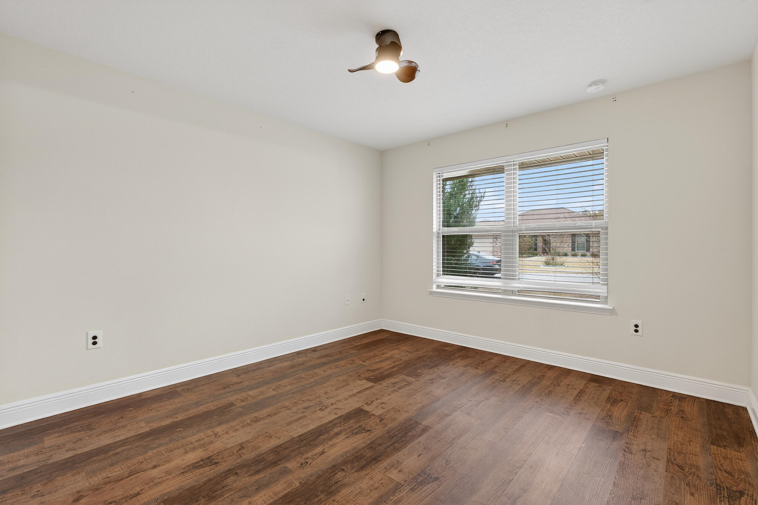 5733 Marigold Loop Crestview, FL 32539 - Photo 11 of 45 a view of an empty room with wooden floor and a window