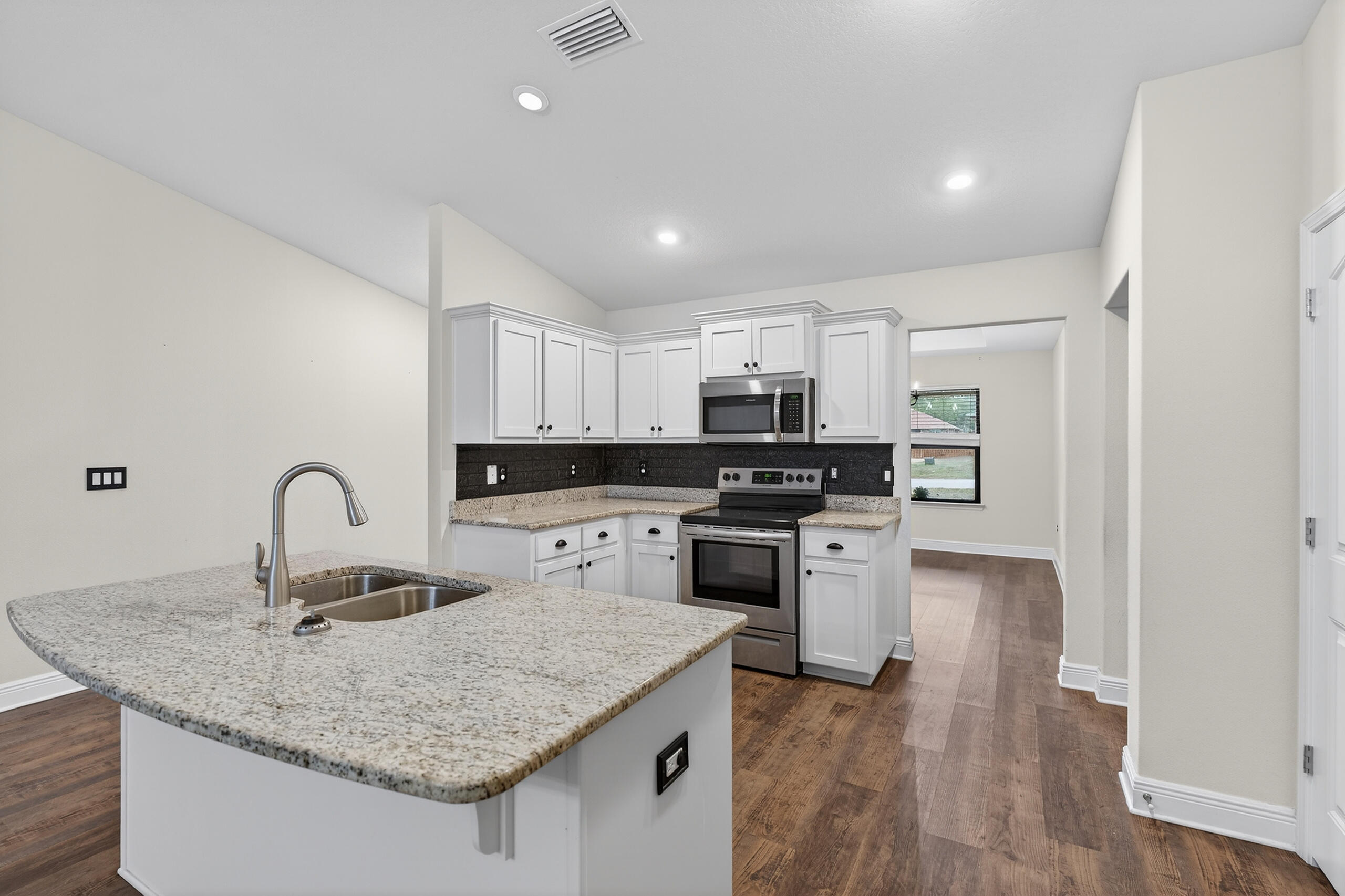 5733 Marigold Loop Crestview, FL 32539 - Photo 17 of 45 a kitchen with stainless steel appliances granite countertop a sink stove and refrigerator