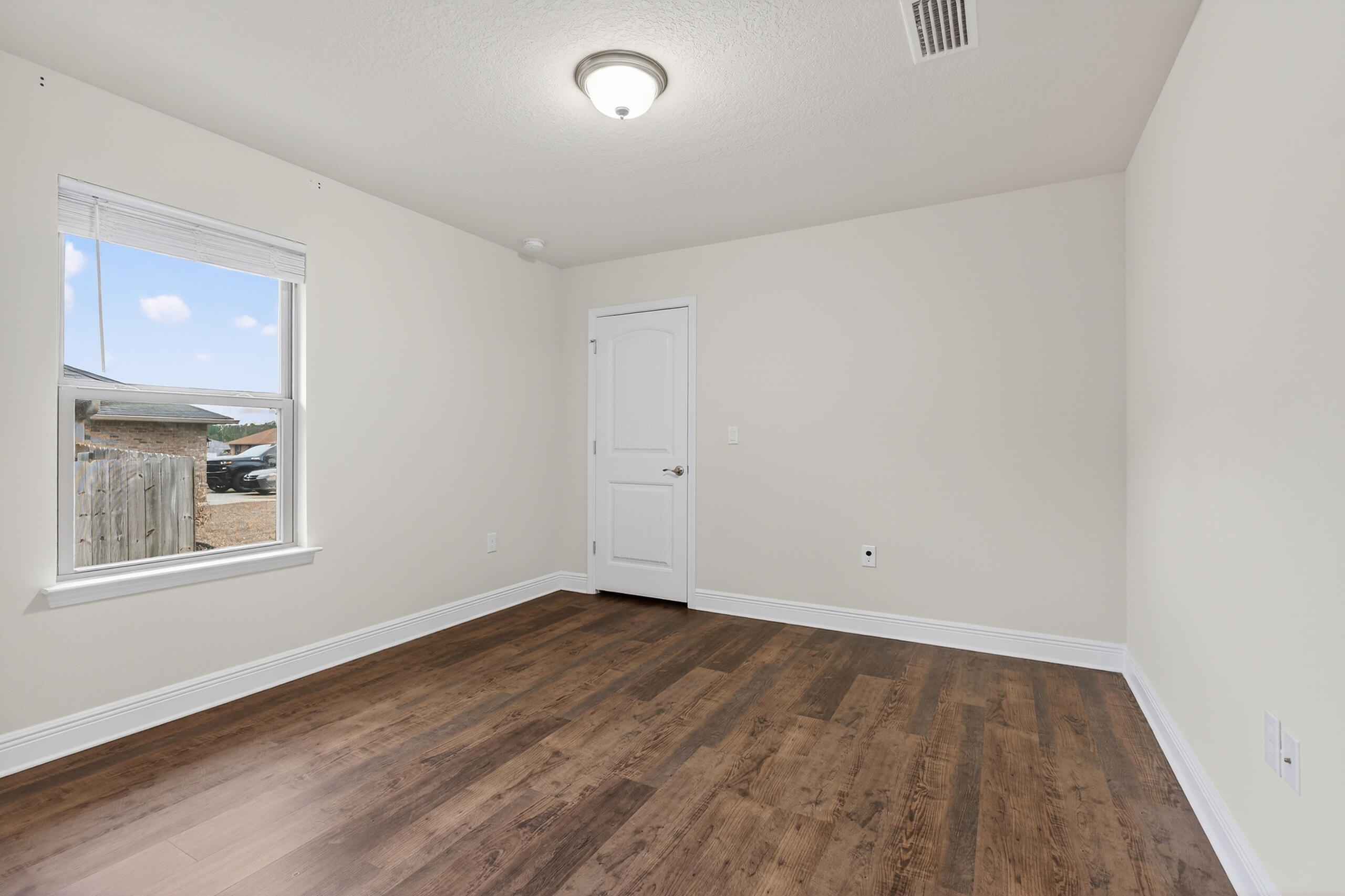 5733 Marigold Loop Crestview, FL 32539 - Photo 23 of 45 an empty room with wooden floor and windows