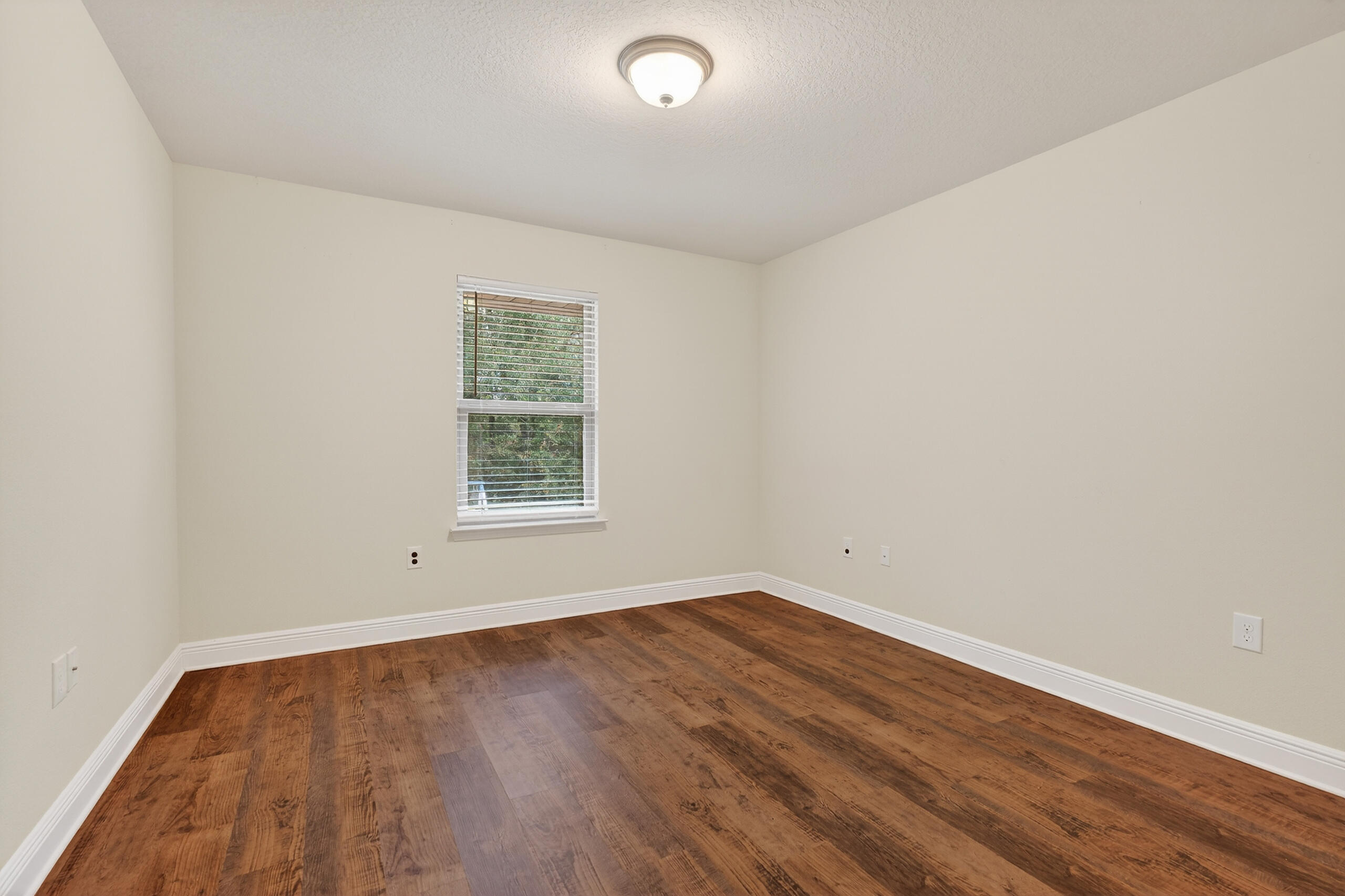5733 Marigold Loop Crestview, FL 32539 - Photo 26 of 45 an empty room with wooden floor and windows