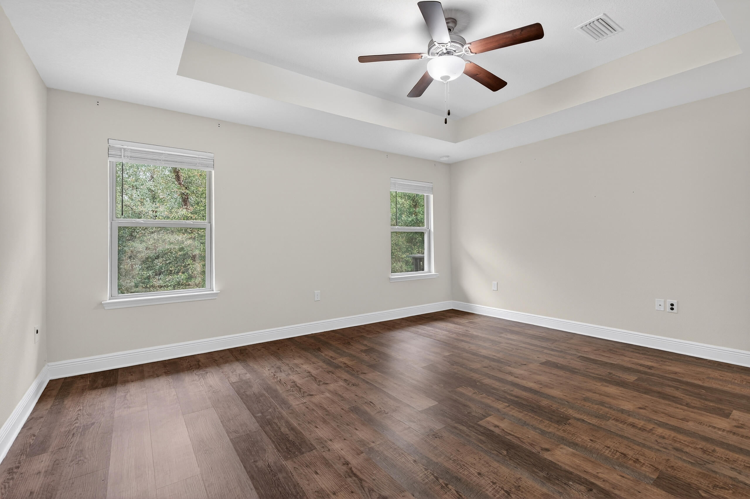 5733 Marigold Loop Crestview, FL 32539 - Photo 29 of 45 an empty room with wooden floor chandelier fan and windows