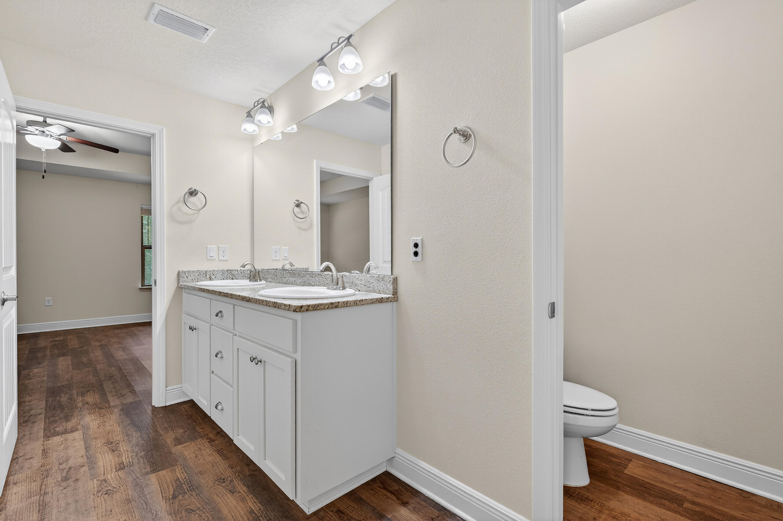 5733 Marigold Loop Crestview, FL 32539 - Photo 35 of 45 a bathroom with a granite countertop sink a toilet and a mirror