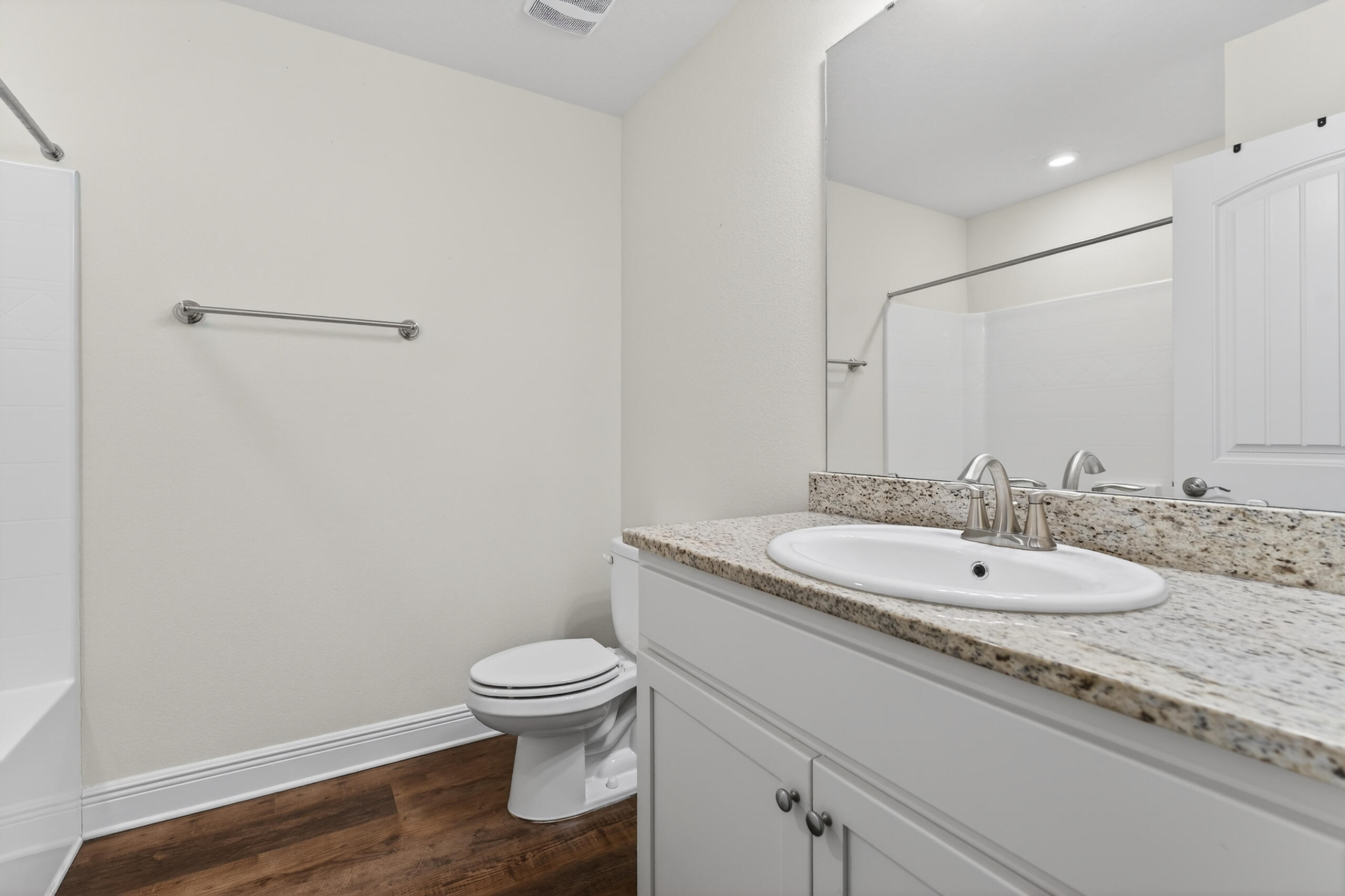 5733 Marigold Loop Crestview, FL 32539 - Photo 36 of 45 a bathroom with a granite countertop toilet a sink and a mirror