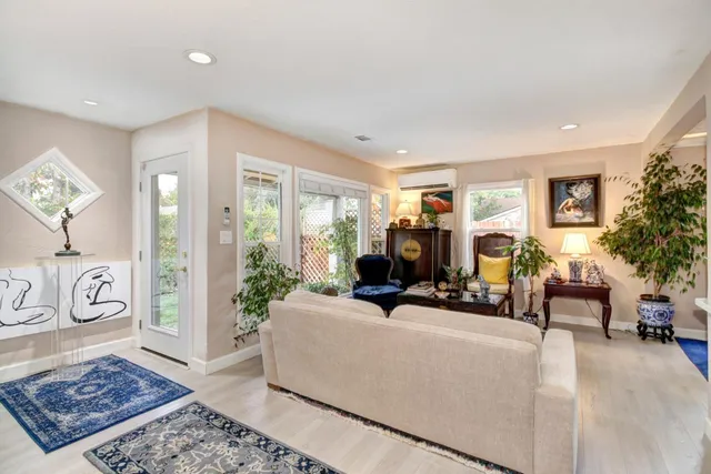 a living room with furniture a rug a window and a fireplace