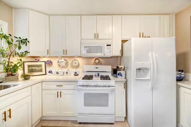 a kitchen with stainless steel appliances white cabinets and a refrigerator