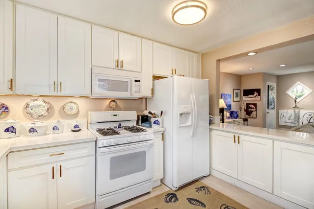 a kitchen with a white stove top oven and white appliances