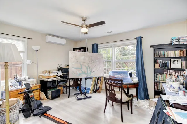 a view of a livingroom with workspace and a window