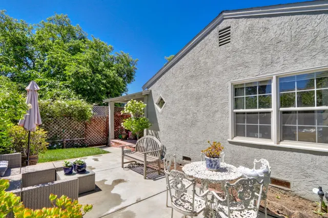 a view of a patio with couches table and chairs and potted plants