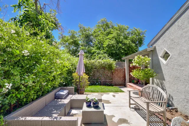 a view of a patio with couches table and chairs and potted plants