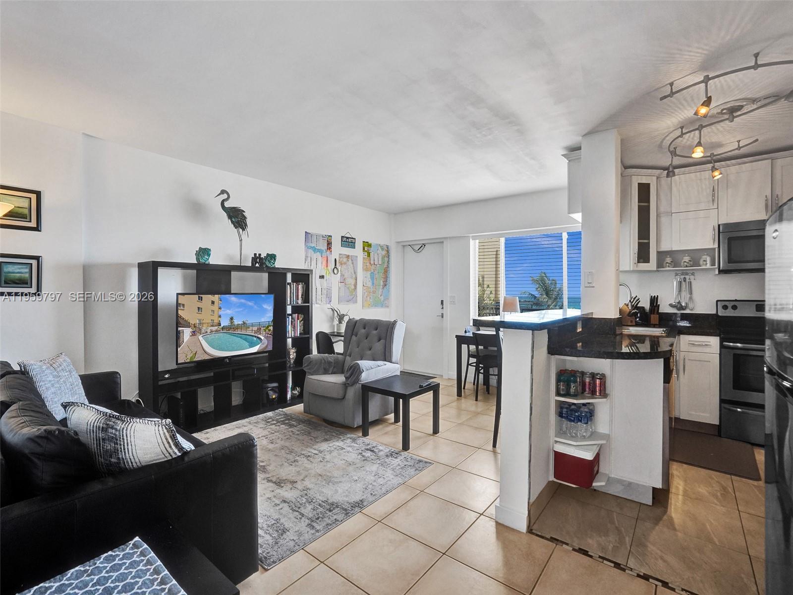 1815 North Surf Road, Unit 202 Hollywood, FL 33019 - Photo 16 of 32 a living room with furniture and a flat screen tv