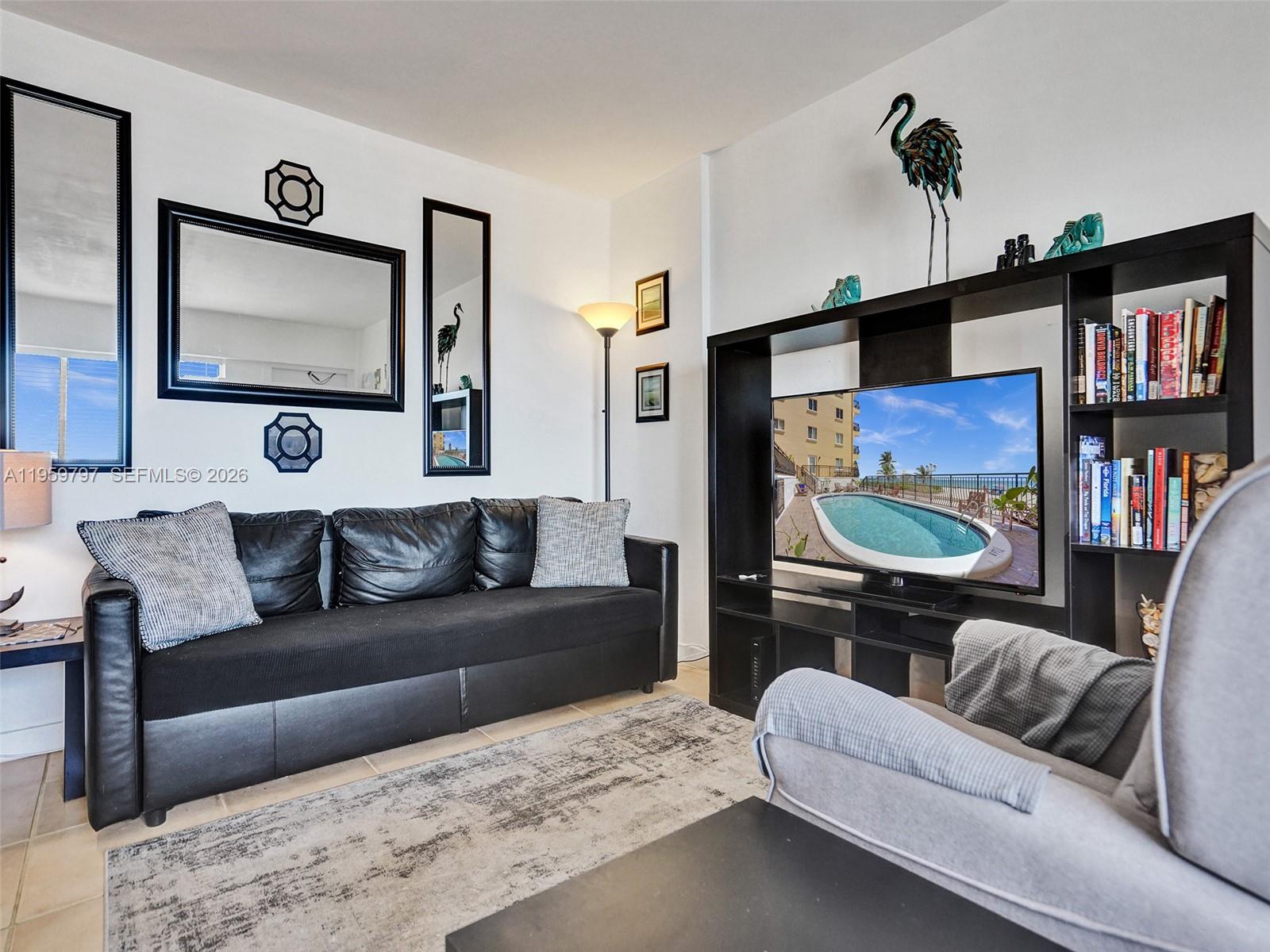 1815 North Surf Road, Unit 202 Hollywood, FL 33019 - Photo 17 of 32 a living room with furniture and a flat screen tv