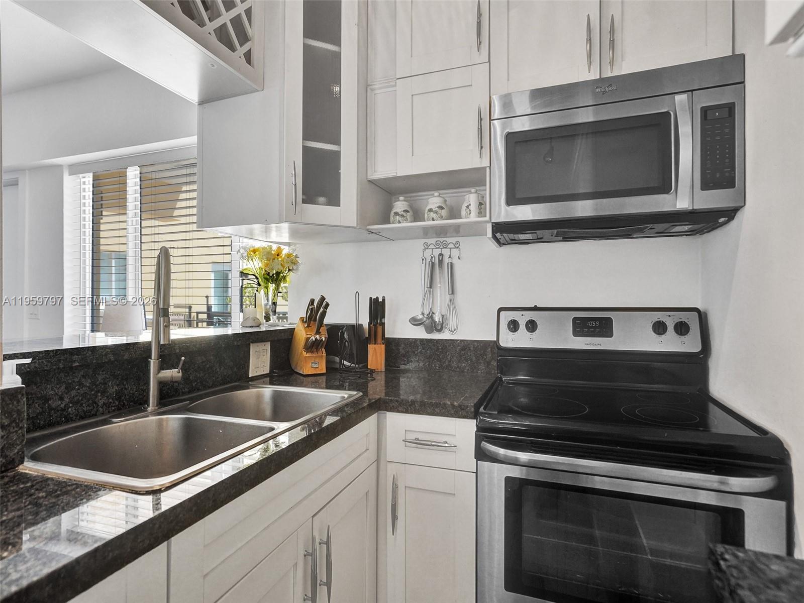 1815 North Surf Road, Unit 202 Hollywood, FL 33019 - Photo 20 of 32 a kitchen with stainless steel appliances granite countertop a sink stove and microwave