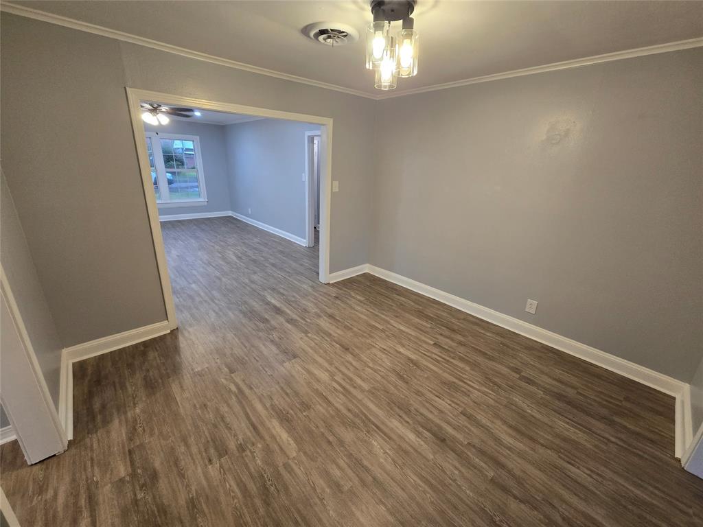 233 Roma Drive Shreveport, LA 71105 - Photo 5 of 12 Empty room with crown molding and dark wood finished floors