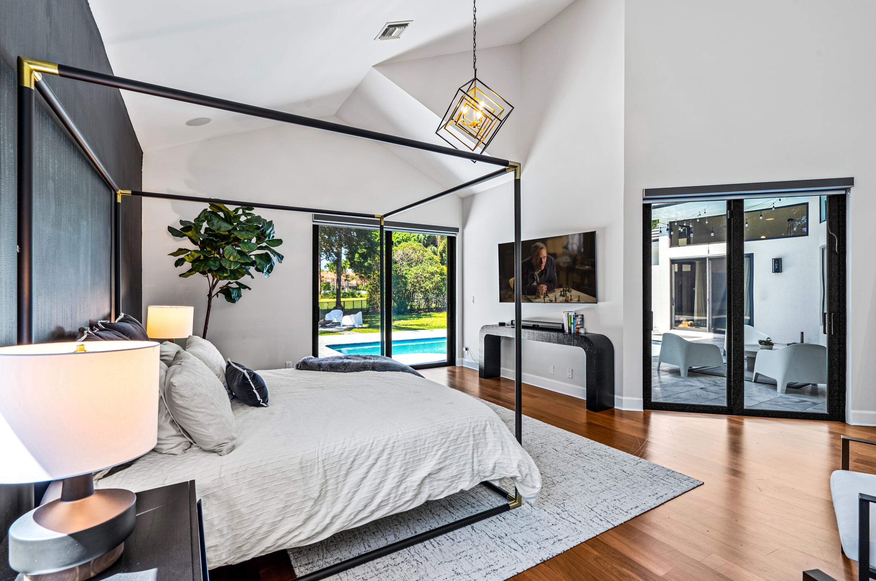 3098 Northwest 60th Street Boca Raton, FL 33496 - Photo 14 of 30 a bedroom with a bed and a flat screen tv