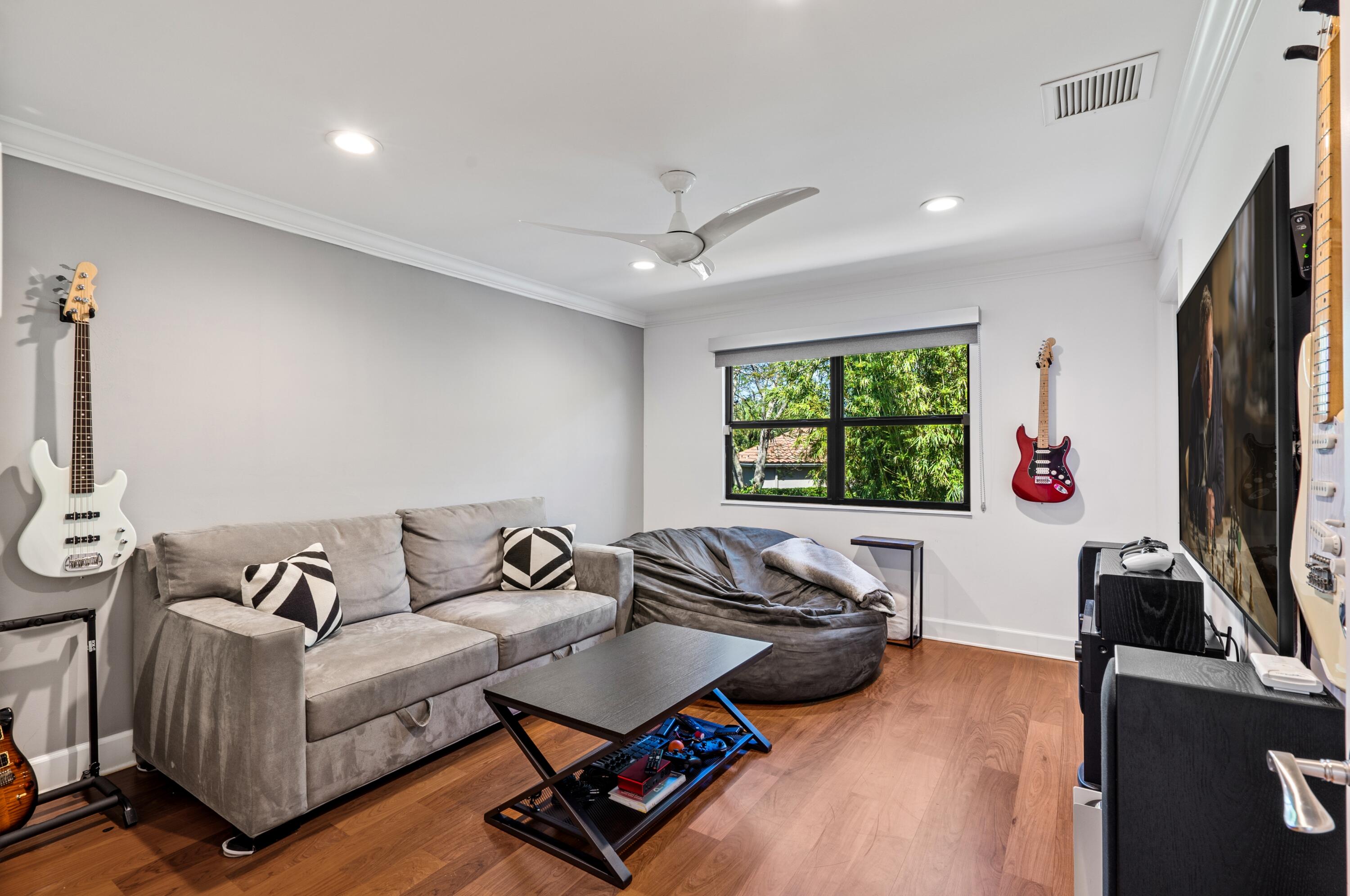 3098 Northwest 60th Street Boca Raton, FL 33496 - Photo 21 of 30 a living room with furniture flat screen tv and a large window