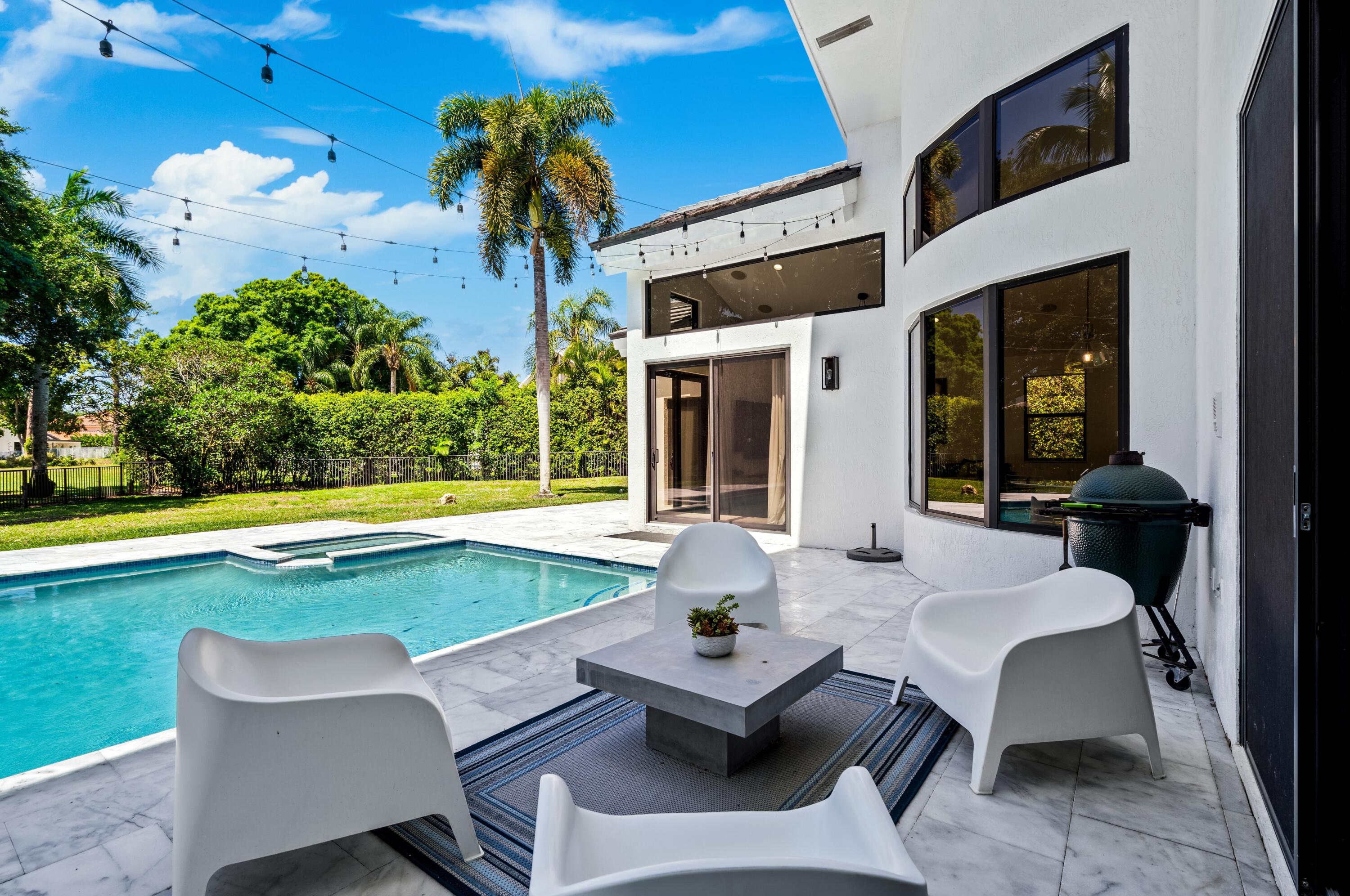 3098 Northwest 60th Street Boca Raton, FL 33496 - Photo 25 of 30 a view of a patio with swimming pool table and chairs